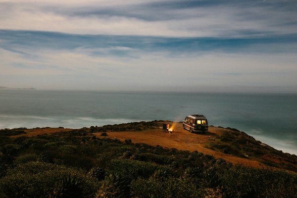 How can you participate in beach clean-ups while camping on UK shores?